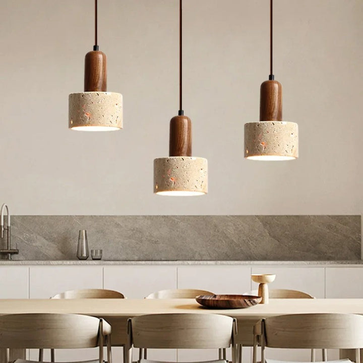 Three pendant lights hanging above a dining table in a UK kitchen setting.