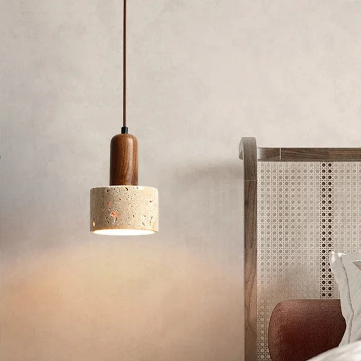 Pendant light with wooden top and concrete base hanging in a room.