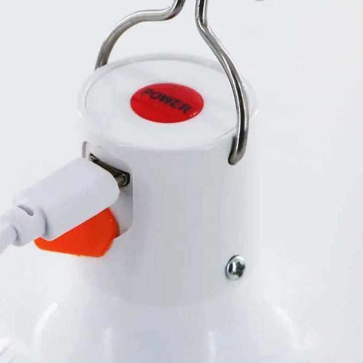 Close-up of USB rechargeable LED camping lamp's power button and charging port, portable hook light