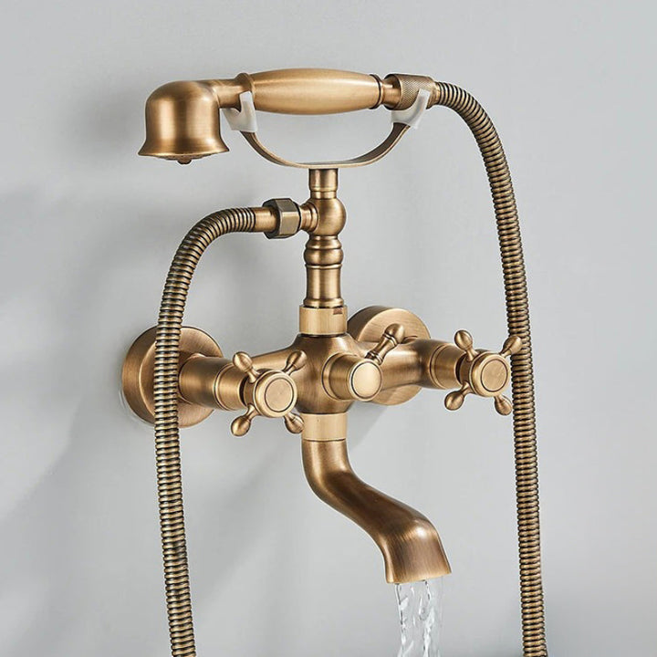 Side view of antique bronze bath faucet set with shower head and braided hose mounted above a bathtub.