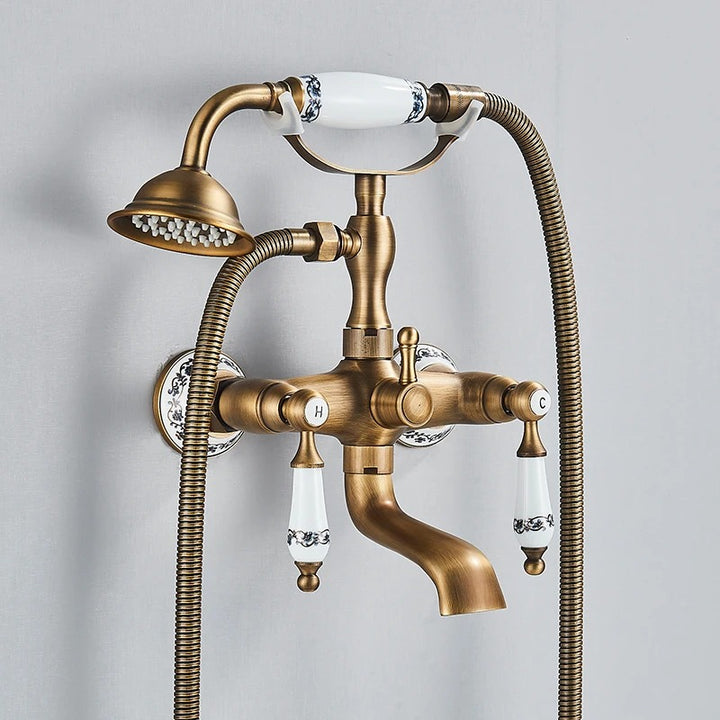 Vintage brushed brass shower and bath faucet set with ceramic handle details and flexible hose.
