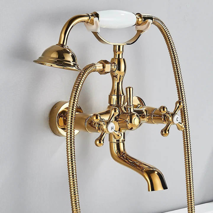 Curved spout vintage brass faucet set with dual-function handheld shower and white ceramic handle lever accents.