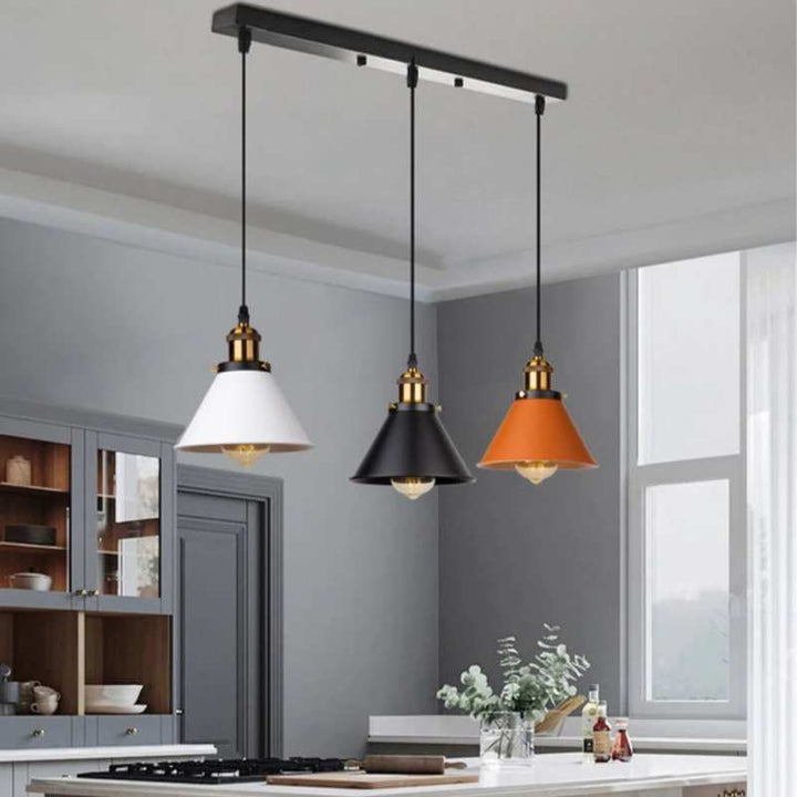 Trio of retro industrial pendant lights above modern kitchen island, Scandinavian style.