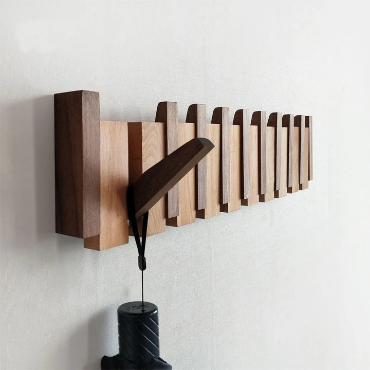 Wooden wall-mounted coat rack with a black lamp on a white background