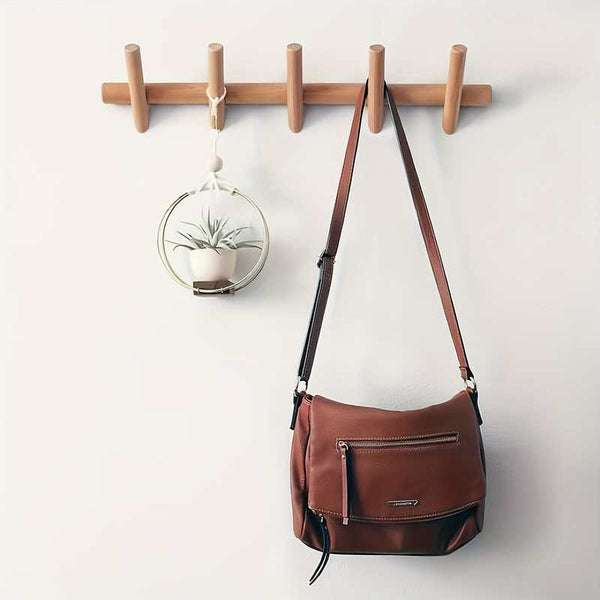 Wall-mounted wooden coat rack used in bright living space, adding warmth and Nordic simplicity