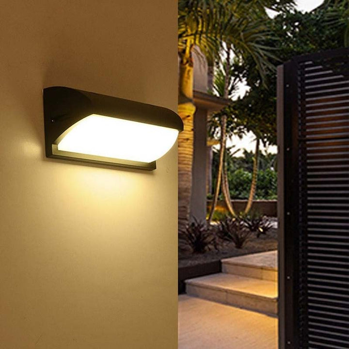 Outdoor wall light fixture on a building exterior with garden and steps in the background