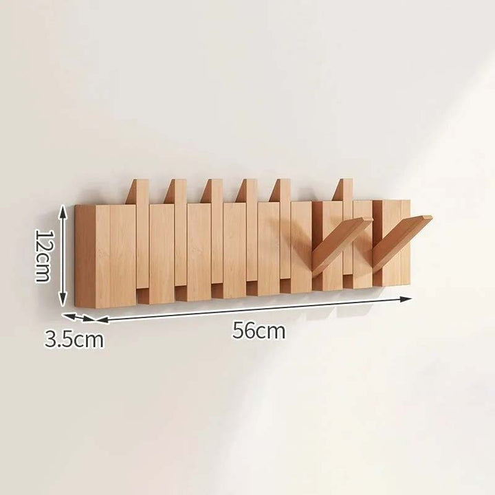 Wooden wall-mounted coat rack with dimensions on a light background