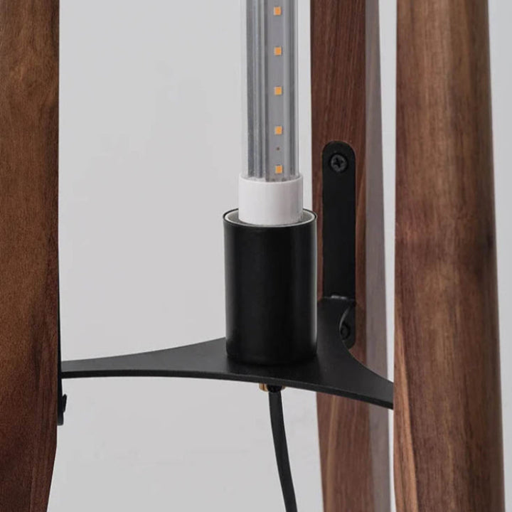 Tall wood floor lamp beside rattan furniture and divider, ideal for boho and Japanese living rooms.