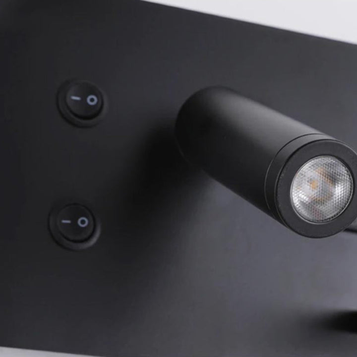 Black wall light fixture with two switches on a dark surface