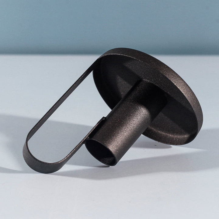 Matte black iron candle holder lying on its side showing handle and tray base details