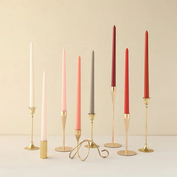 Gradient wax taper candles in gold holders, red/grey/pink, minimalist table décor