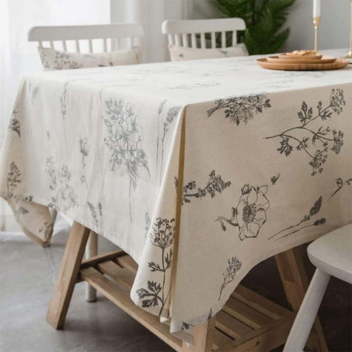 Cotton - linen tablecloth with floral pattern on a wooden table in a bright room