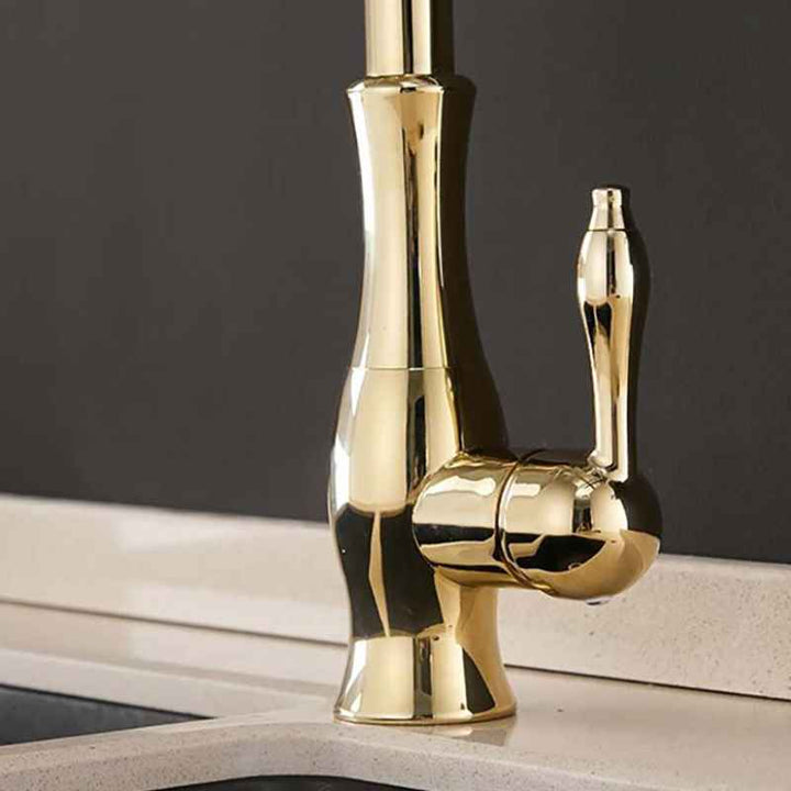Close up of a gold faucet on a dark background